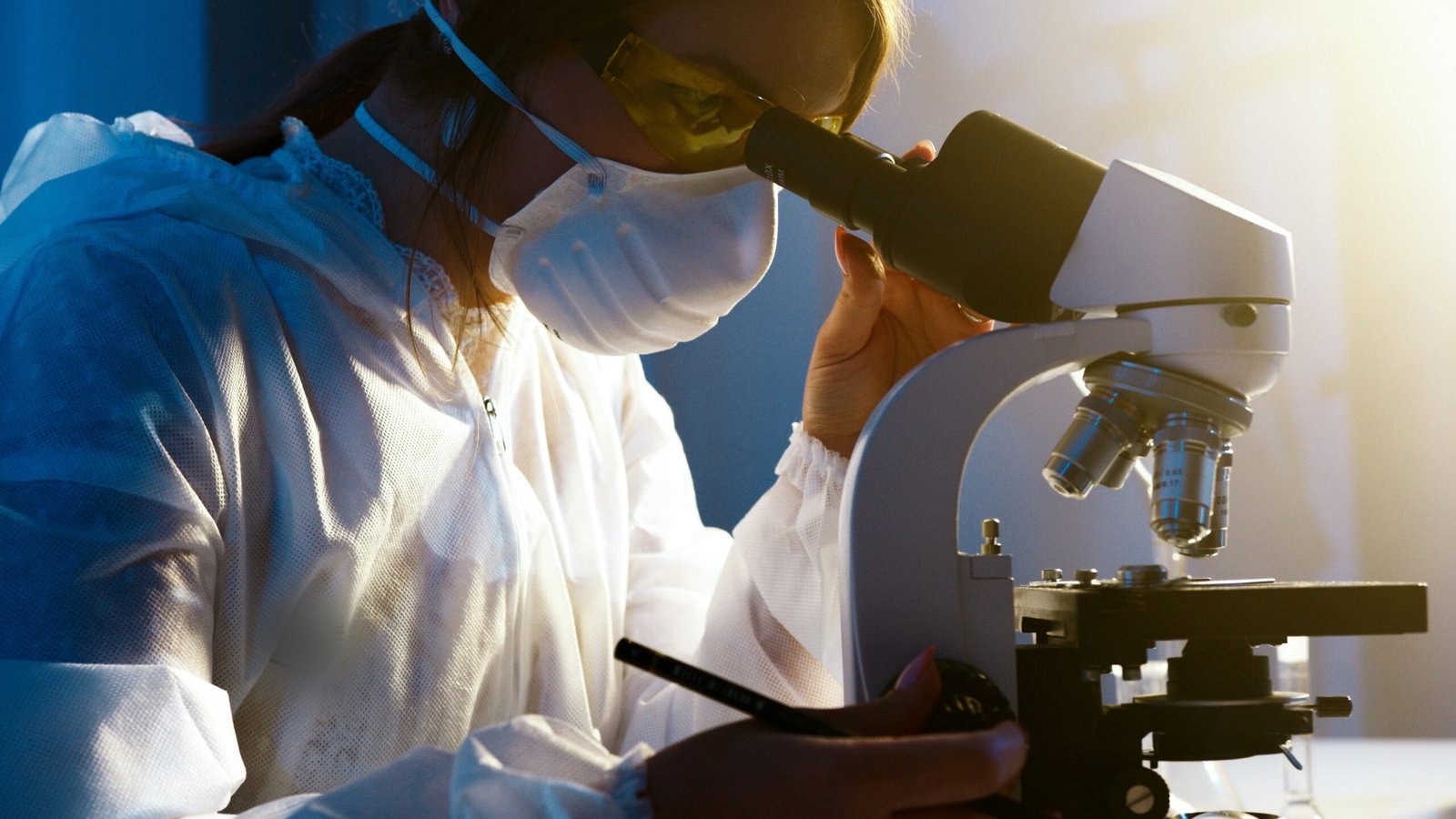 pexels-photo-5726794-5726794-scaled A female scientist uses a microscope in a laboratory, focusing intently on her research.